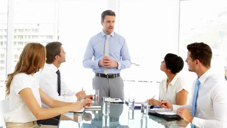 hombre de negocios de pie y hablando durante la reunión