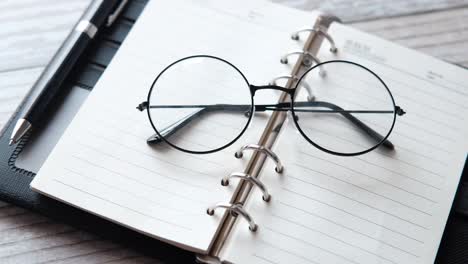 open notebook with glasses and pen