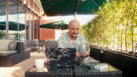 Un-Trabajador-Masculino-Atractivo-Está-Usando-Una-Computadora-En-La-Cafetería.