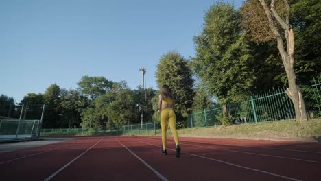 woman jogging on outdoor track in sportswear at athletic field