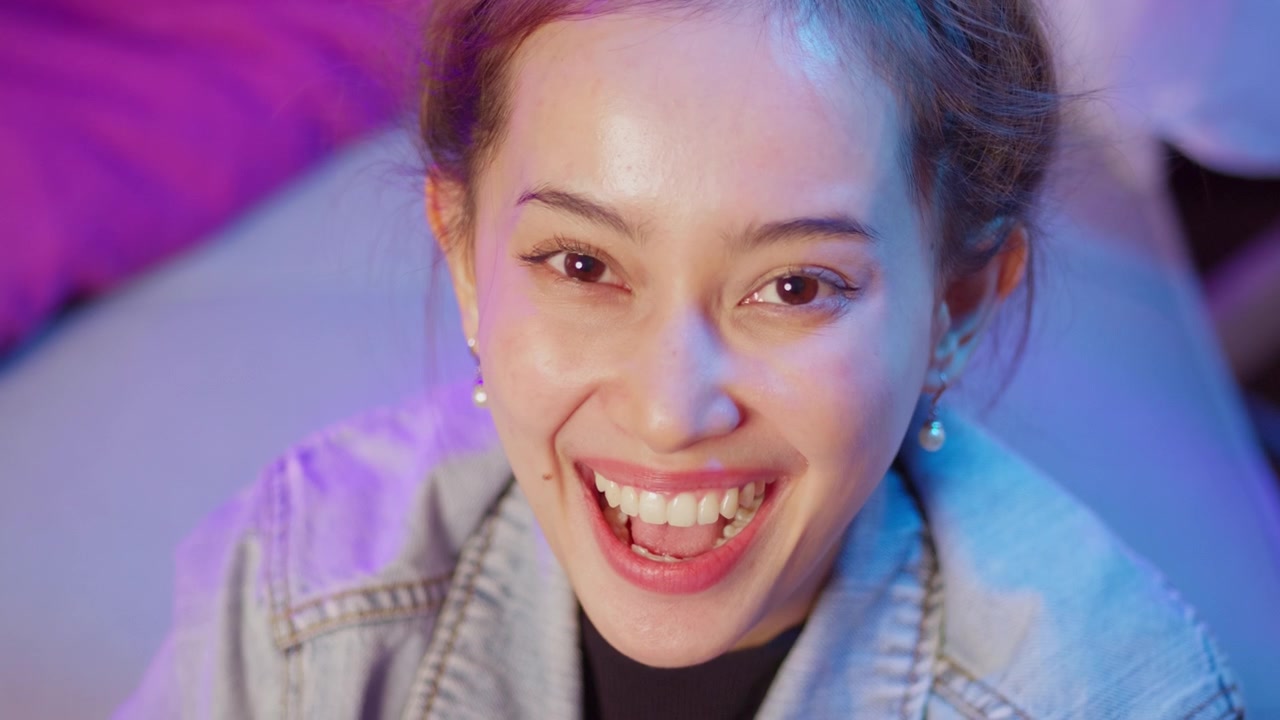 A bright moment sharing joy at home showcasing a young woman's cheerful expression and vibrant energy.