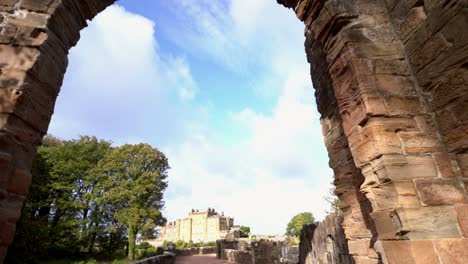 view through an ancient stone archway towards a historic castle ruin