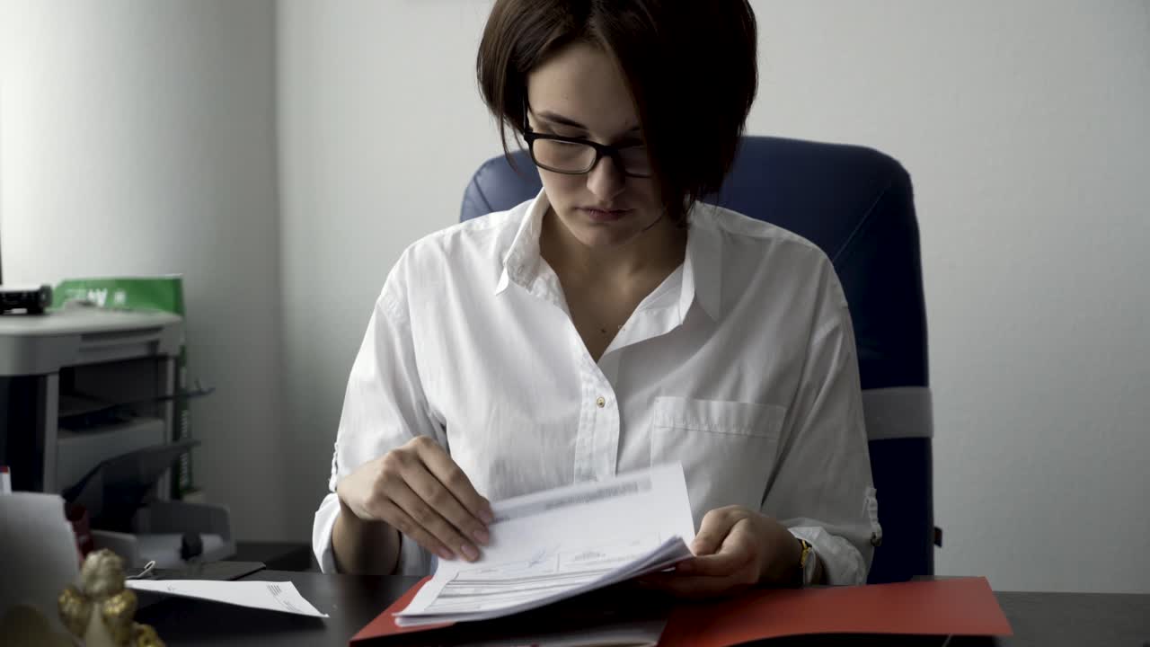 mujer leyendo documentos en la oficina