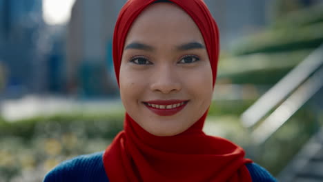 close-up portrait of a smiling young muslim woman in a red hijab