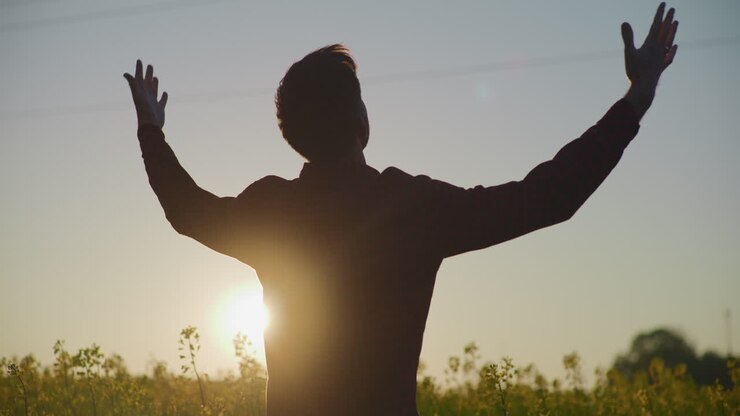 Farmer Silhouette at Sunset with Raised Arms