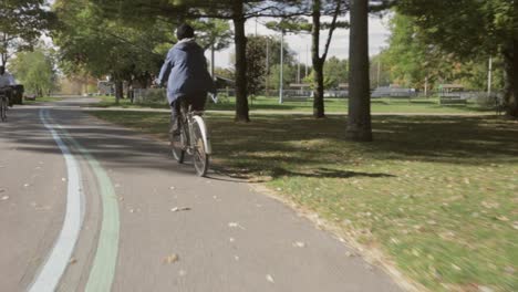 follow shot tracking a cyclist out for a bike ride during a bright sunny day