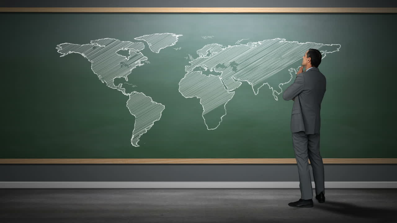Een zakenman die naar een wereldkaart kijkt.