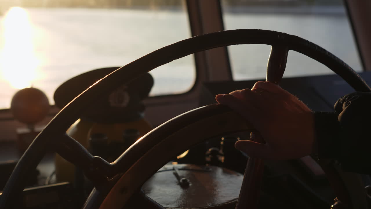 A ship's steering wheel at sunset