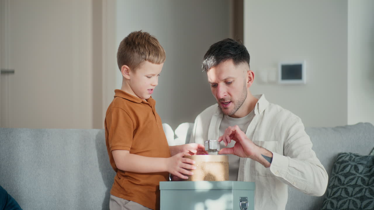 el niño y su padre miran a través de las latas de hornear y se preparan para la navidad