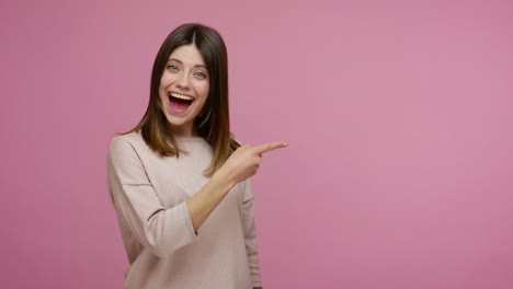 surprised brunette woman pointing empty place and showing thumbs up, looking with open mouth, amazed expression