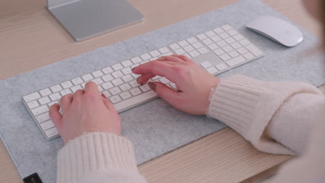 remote work concept - woman working at home typing on a wireless keyboard