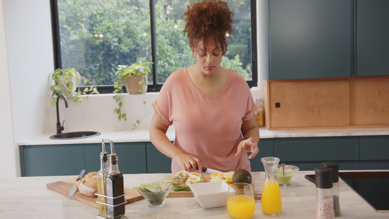 Donna che taglia le verdure, preparando un pasto sano in una cucina moderna.