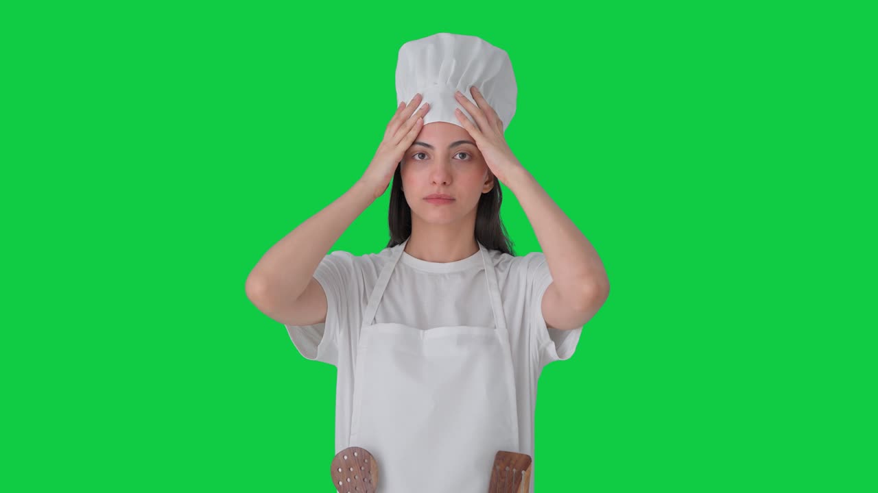 Cuoca professionista indiana con cappello e grembiule su sfondo verde