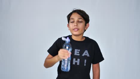 Schoolboy-drinking-water-from-plastic-bottle-isolated-on-white-background