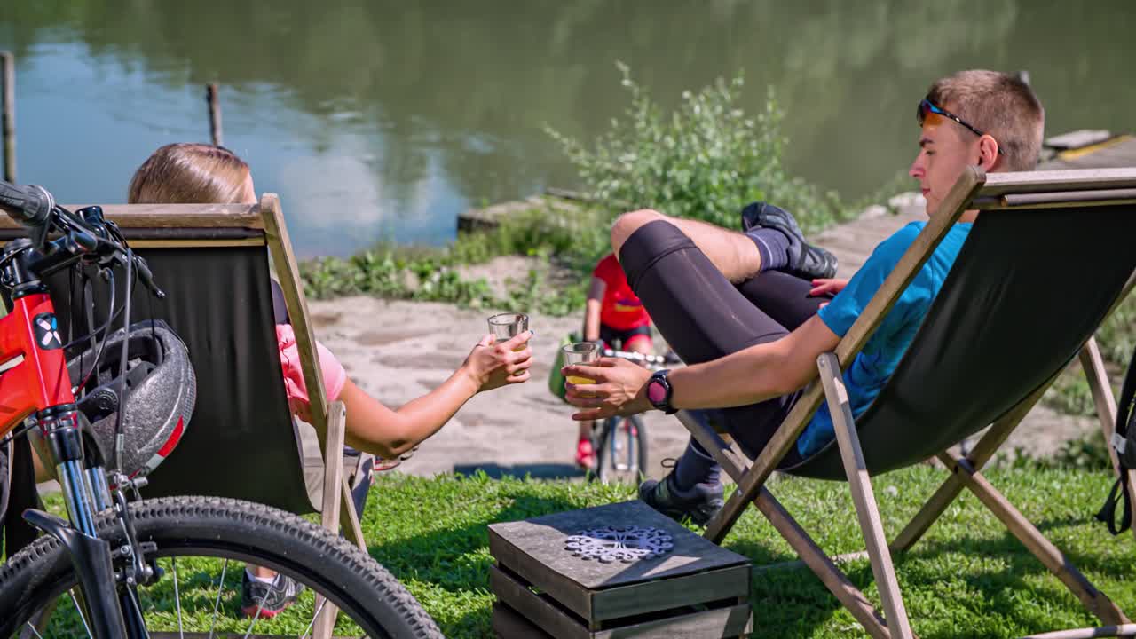 Drinking , cycling and canoeing. Friends enjoying fun activities by the river