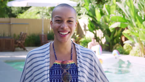 Portrait-Of-African-American-Woman-With-Shaved-Head-Outdoors-With-Friends-Enjoying-Summer-Pool-Party