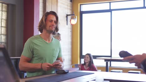 man giving his credit card to a bartender.