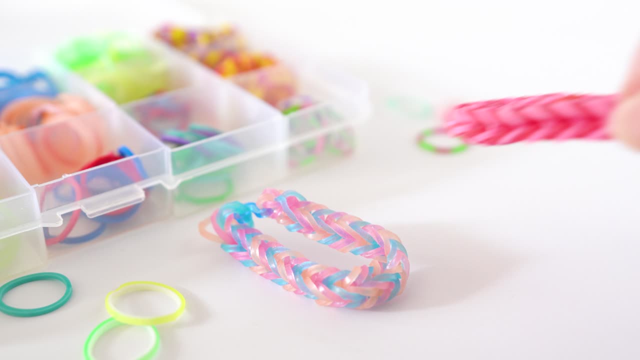 trabajo de bricolaje infantil, pulsera de mano de banda de goma colorida y creativa sobre fondo blanco