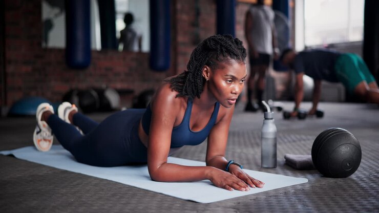 Woman doing plank exercise in gym
