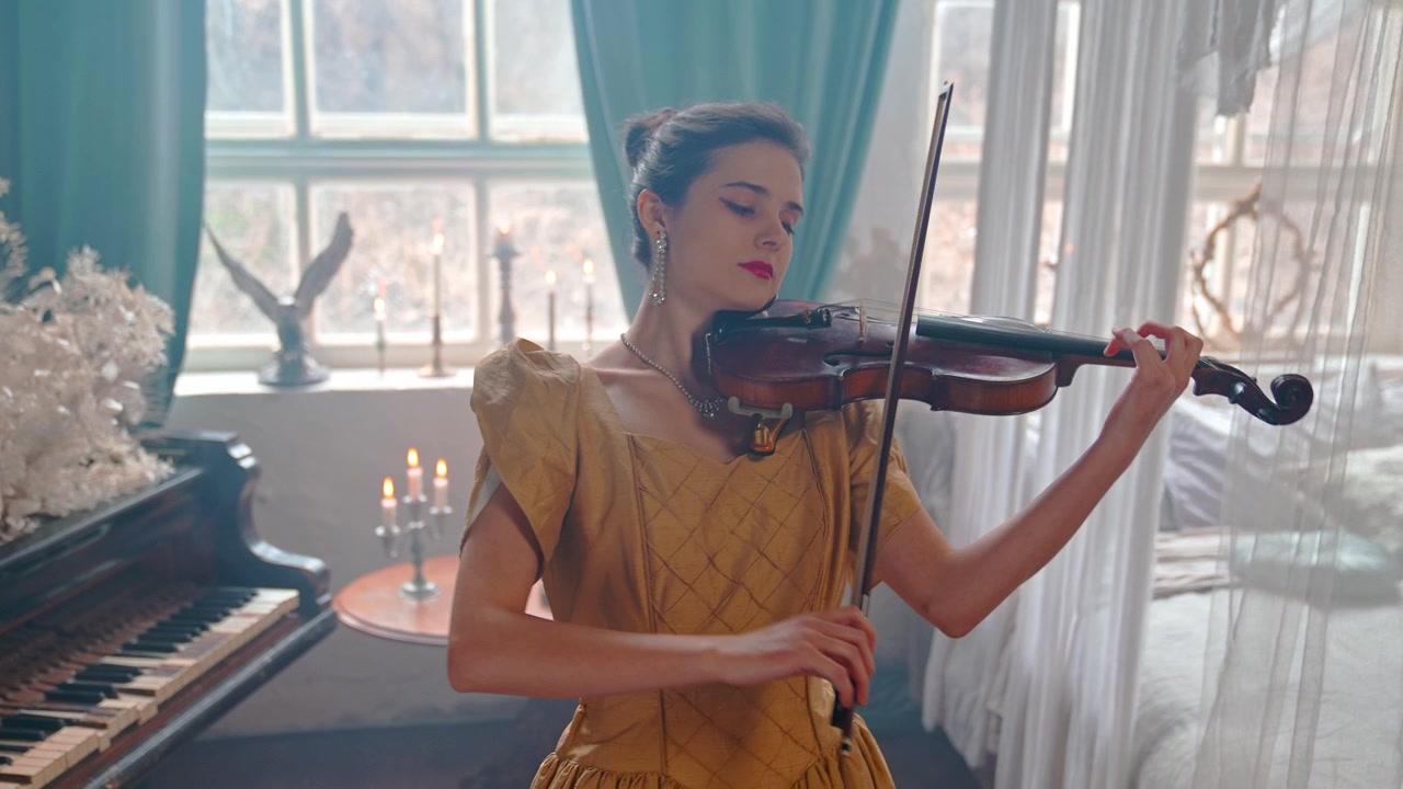 Donna elegante in abito dorato che suona il violino in una stanza vintage