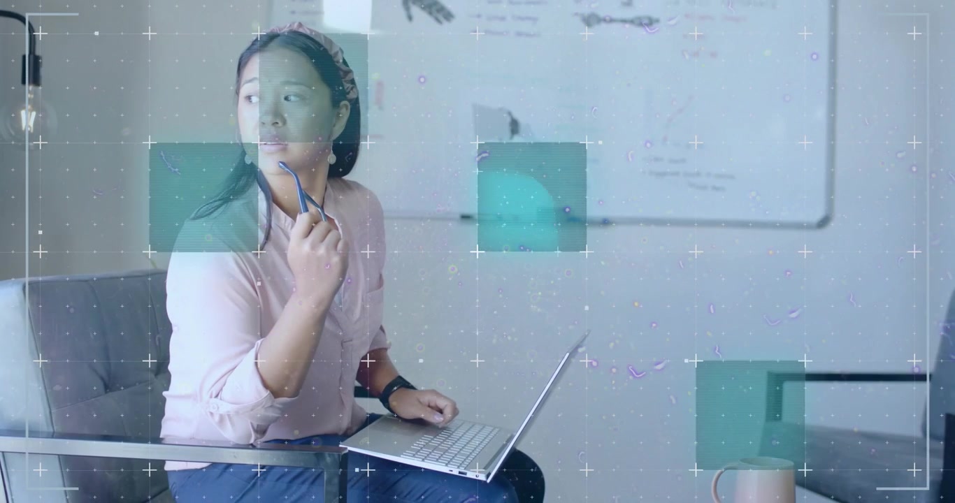 Donna che scorre lo schermo del laptop toccando con la penna attiva sovrapposizioni di dati verde acqua e viola per l'analisi tecnologica