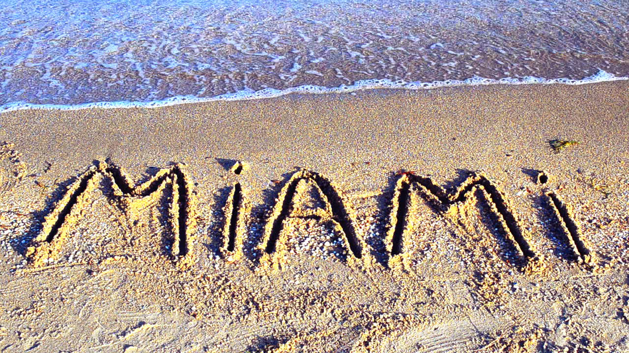 Indskriften "Miami" i sandet. Indskrift på sand