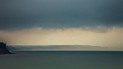 Ein-Blick-Auf-Den-Sonnenuntergang-An-Der-Küste-Bei-Bewölktem-Wetter-Und-Einer-Fernen-Berglandschaft