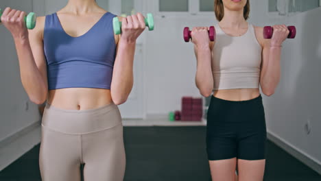 sport couple dumbbells workouting at house closeup. athletic women exercises