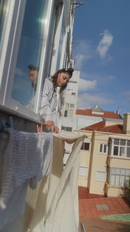 woman drying clothes on balcony