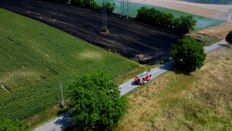 firefighters extinguishing fire burning agricultural field in summer