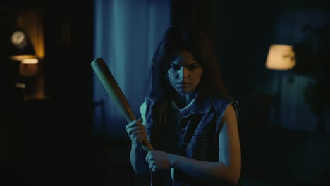girl in casual with angry face expression looking at the camera holding baseball bat ready to fight