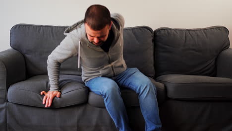hombre caucásico barbudo acostado en un sofá en casa