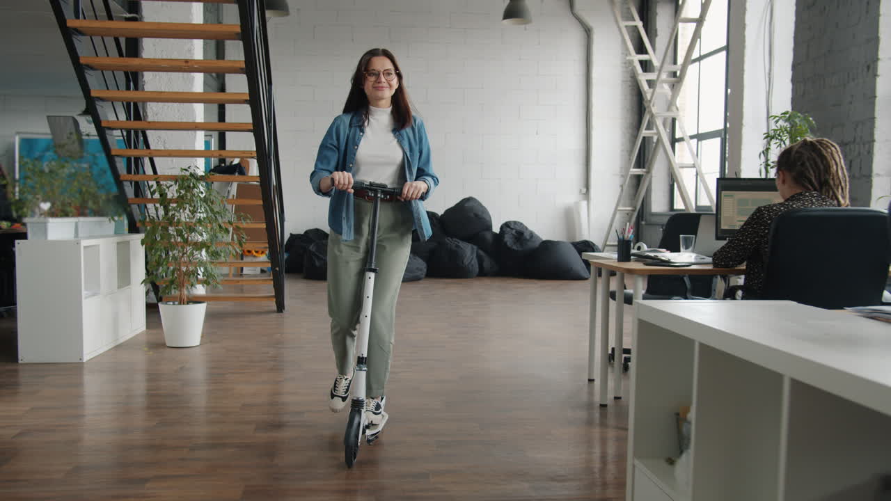 Woman Riding Scooter in Modern Open-Plan Office