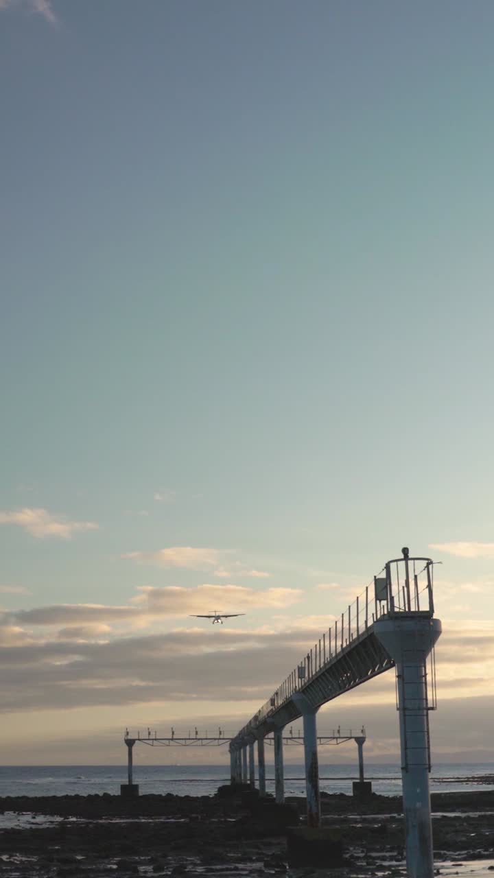 해가 지면 바다 위에 착륙하는 비행기