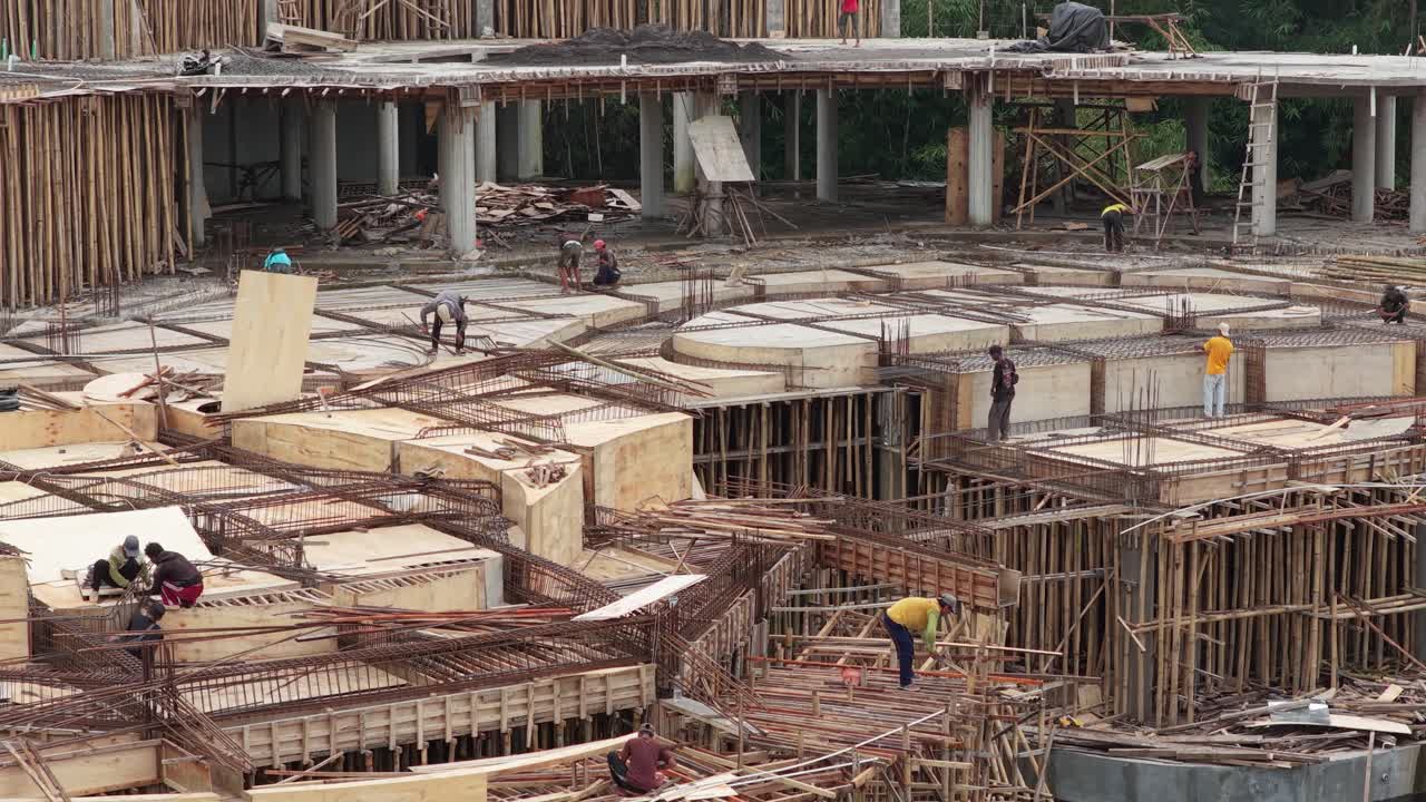 Construction workers building a large concrete foundation