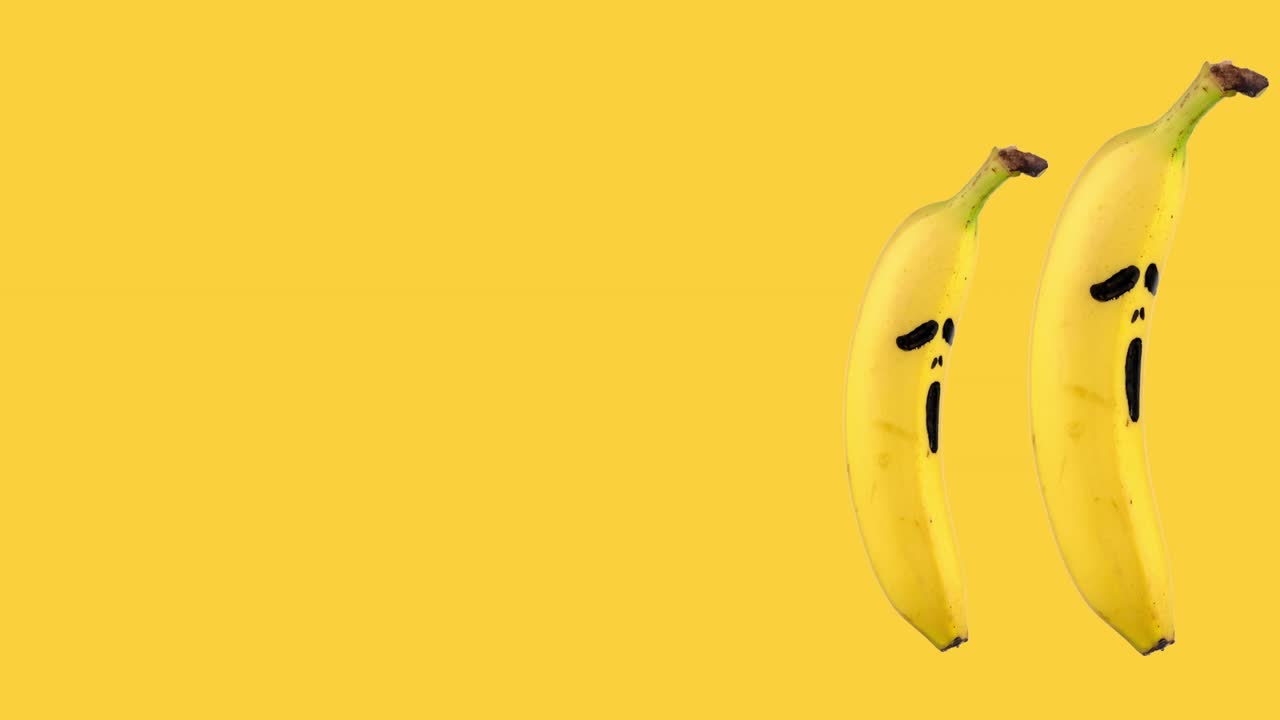 노란색 배경에 두려움의 무서운 마스크를 그린 두 개의 바나나의 원활한 루프 애니메이션. 복사 공간에 대한 할로윈 개념