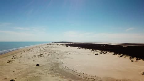 drone - aumento, revela la vista de la costa y las dunas de arena en una isla de barrera de la costa del golfo en una tarde soleada, pescadores y vehículos en la distancia - isla del padre sur, texas