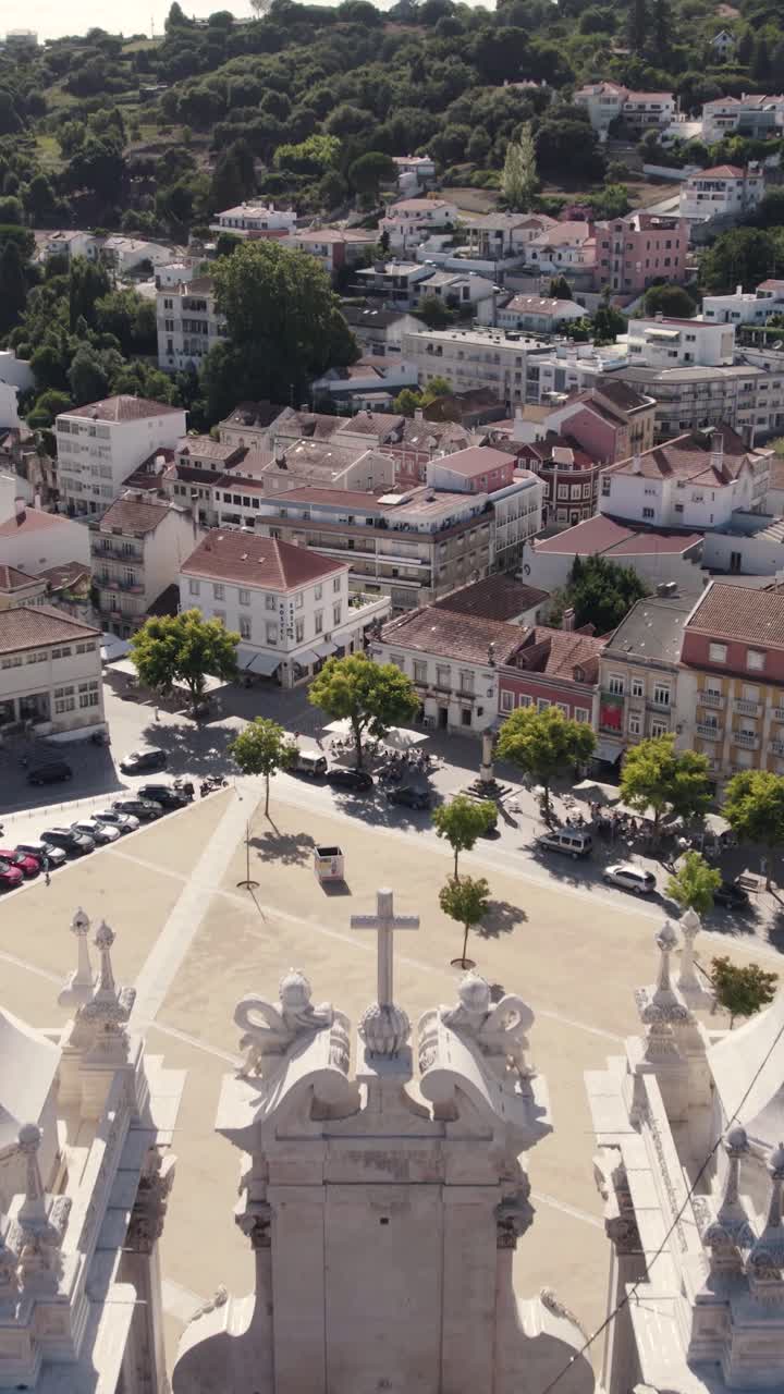 Toma aérea vertical volando sobre las dos impresionantes torres de la iglesia del Monasterio de Alcobaça hacia la ciudad