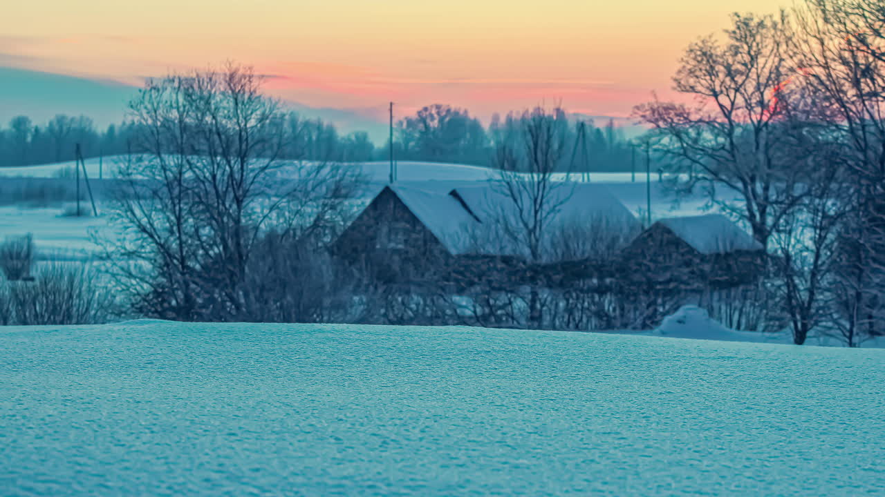 일출 때 겨울 설원 사이 도로에서 운전하는 자동차의 저속 촬영