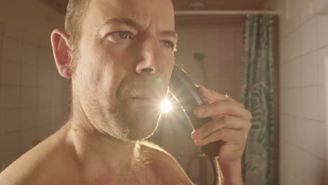 slow motion, wide, a man in bathroom having almost finished shaving