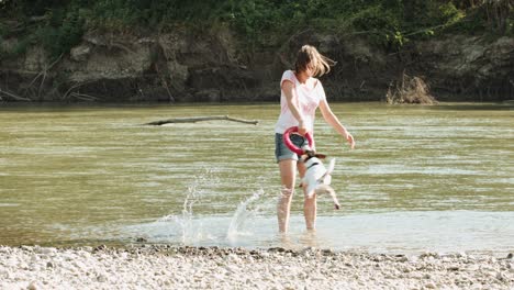 woman playing with dog near river