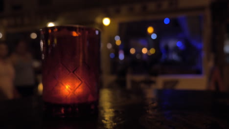 Lit-candle-and-people-in-night-street