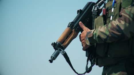 an army soldier holds a gun in his hand