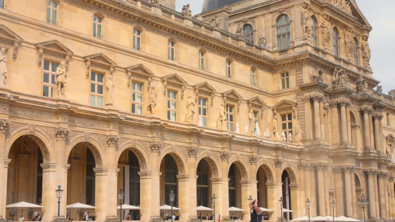 View of exterior architectural details of Louvre Museum in Paris, France during daytime. 4k.