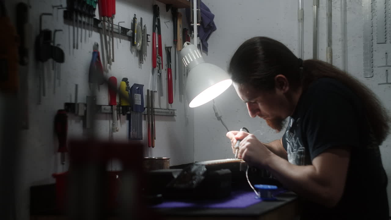 Man Repairing Electronics in a Workshop