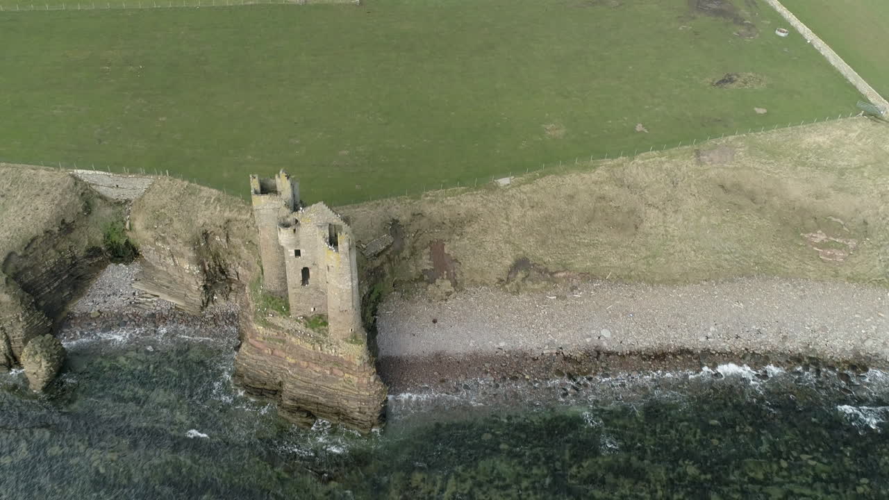 Luftfoto, der trækker sig tilbage fra over Keiss Castle ud mod havet på en solskinsdag, Caithness, Skotland