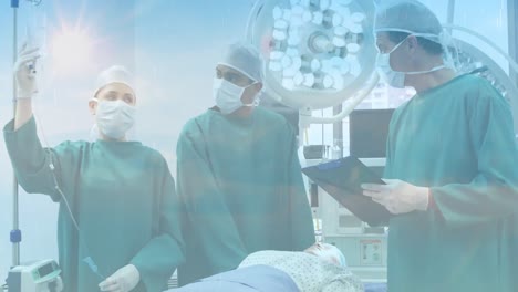 Animation-of-clouds-and-sky-over-surgeons-wearing-face-masks-in-hospital