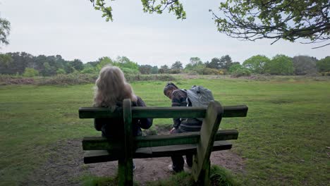 two female walking friends sit enjoying companionship among peaceful nature