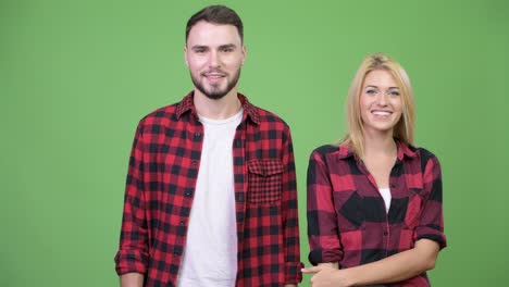 young happy couple showing something together