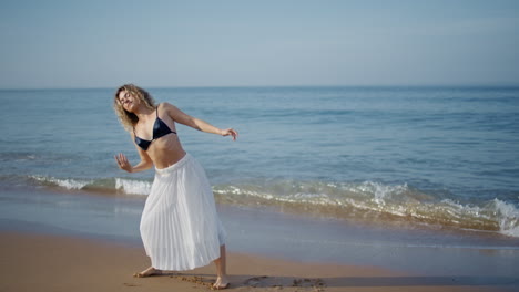 graceful girl dancing seascape summer evening. curly woman dancer moving body